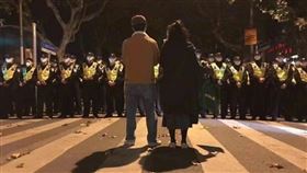 杜承哲醫師27日晚間在臉書轉貼一張網路流傳的照片，他說，上海復旦大學的兩位教授，凜然在抗議學生的面前阻擋警察。這不是1989年，是昨夜。（圖／翻攝自杜承哲醫師臉書）

