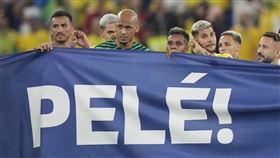 巴西球員拿著有球王比利（Pele）名字和照片的橫幅進入球場向球王比利致敬。（圖／美聯社／達志影像）