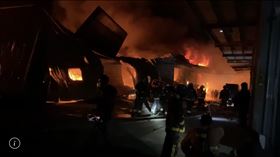 ▲新北市八里一處工廠晚間7點多發生火警，現場為連棟鐵皮屋，共8間燃燒，傳出1名消防隊員臉部、手部灼傷，被緊急送醫急救。（圖／民眾提供）