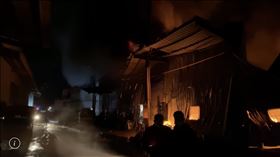 ▲新北市八里一處工廠晚間7點多發生火警，現場為連棟鐵皮屋，共8間燃燒，傳出1名消防隊員臉部、手部灼傷，被緊急送醫急救。（圖／民眾提供）