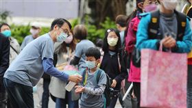 北市國小開學（3）台北市高中以下各級學校13日開學，學生上午前往松山國小返校上課，老師在校門口幫孩子消毒、噴酒精防疫。中央社記者裴禛攝  112年2月13日