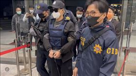 ▲88槍擊案「紅龜」洪政軍(中，白外套遮手)和槍手孔祥志被押抵回台南。警方仍重裝戒備不敢大意。（圖／翻攝畫面）