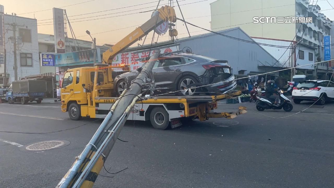 拖吊車的吊臂扯到電線，使得電線桿倒下砸到轎車