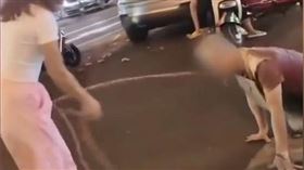 女子用鐵鍊牽著一名男子，男子還不斷跪在地上爬行。（圖／翻攝自七環視頻）