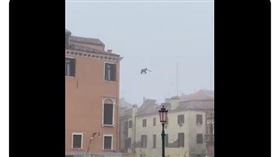 近日義大利一名男子站在3層樓高的房屋，往威尼斯運河一躍而下。（圖／翻攝Luigi Brugnaro推特）