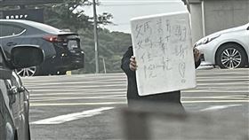 ▲國道一號林口南下匝道口，楊男拎著牌子，走到斑馬線中央突然舉牌、下跪磕頭。警方到楊，楊男卻又拒絕協助。（圖／翻攝自臉書林口大家庭粉專、翻攝畫面）