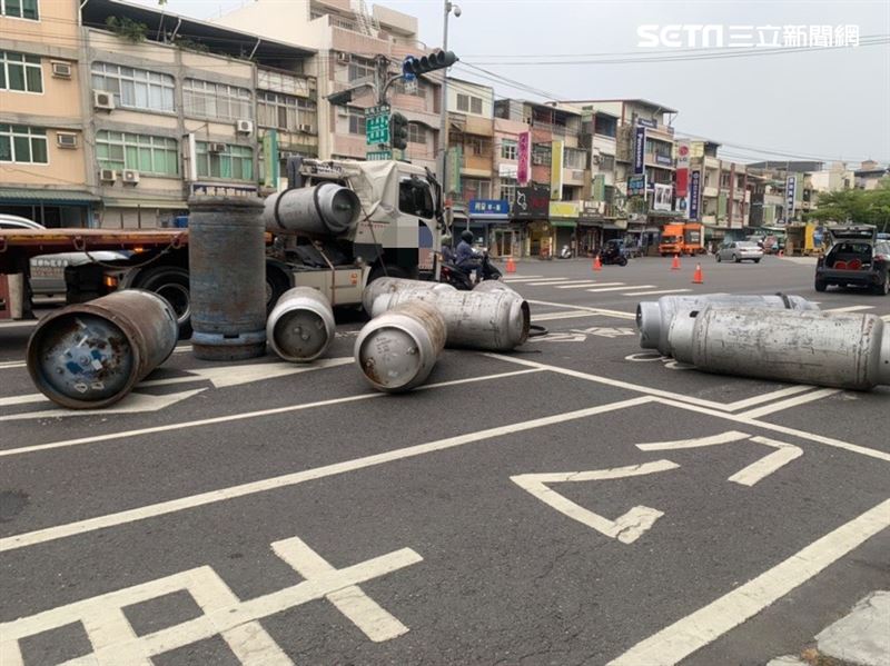 曳引車後車斗9鋼瓶滾落馬路，員警獲報趕往現場處理。（圖／翻攝畫面）