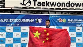 台灣跆拳道選手李東憲在亞太壯年運動會跆拳道拿下銅牌後，在頒獎台高舉中國五星旗，圖翻攝自微博