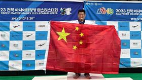 台灣跆拳道選手李東憲在亞太壯年運動會跆拳道拿下銅牌後，在頒獎台高舉中國五星旗，圖翻攝自微博