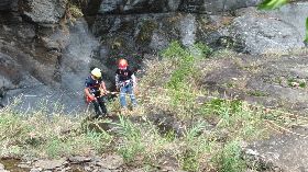 搜救人員垂降搬運吊勾岩壁女死者遺體（