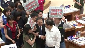 侯友宜出席餵藥案專案報告，民進黨議員舉牌抗議。