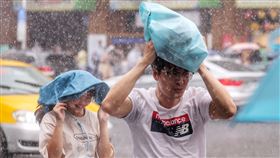北市午後大雨滂沱　民眾急擋雨中央氣象局持續更新大雨特報，因對流雲系發展旺盛，4日大台北、桃園、高雄地區及西半部、東北部山區有局部大雨發生機率，需注意雷擊、強陣風及溪水暴漲。圖為午後台北中山商圈大雨滂沱，路上行人以隨身物品勉強遮擋雨勢。中央社記者趙世勳攝  112年6月4日