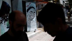 塔利班下令美容院關門，圖為美容院外女性照片遭到污損。（圖／路透社／達志影像）