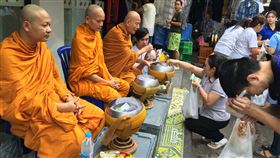 泰人普信佛教　知足的生活哲學泰國民眾普遍信奉佛教，布施是佛教徒每日功課之一，圖為泰國和尚在街頭接受民眾供奉。中央社記者劉得倉曼谷攝　106年12月13日