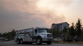 加拿大西北地區的野火讓黃刀鎮安危受到威脅，圖為黃刀鎮的消防車離開一處社區。（圖／路透社／達志影像）