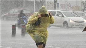 高雄豪雨特報（2）中央氣象局17日發布豪雨特報，並針對高屏發布大雷雨即時訊息。圖為高雄市新興區民眾穿著輕便雨衣、拉緊帽子在大雨中過馬路。中央社記者董俊志攝  112年8月17日