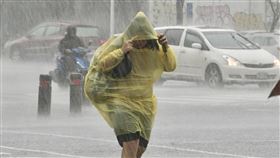 高雄豪雨特報（2）中央氣象局17日發布豪雨特報，並針對高屏發布大雷雨即時訊息。圖為高雄市新興區民眾穿著輕便雨衣、拉緊帽子在大雨中過馬路。中央社記者董俊志攝  112年8月17日