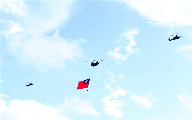 雙十國慶國軍展開空中全兵力預演，兩架UH-60M黑鷹直升機、一架CH-47SD直升機吊掛巨幅國旗橫越總統府。（圖/記者邱榮吉攝影）