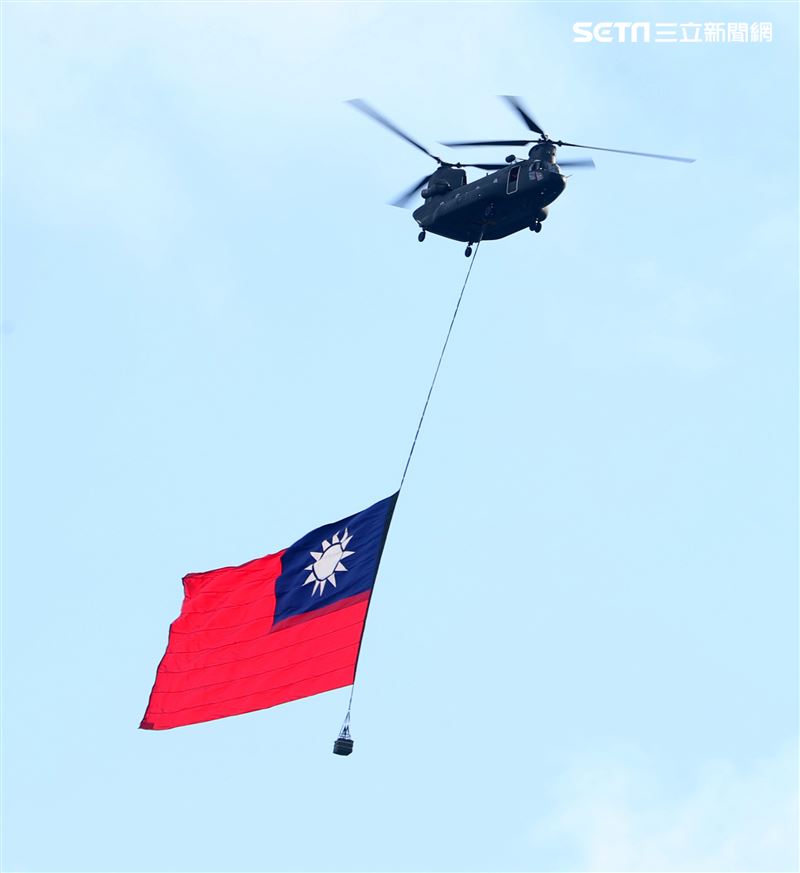 CH-47SD運輪直升機，吊掛巨幅國旗橫越總統府前。（資料照片）（圖/記者邱榮吉攝影）