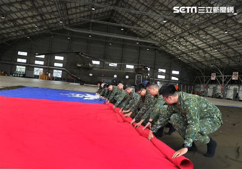 CH-47SD運輪直升機，吊掛尺寸長18公尺、寬12公尺的巨幅國旗4員壓旗手1員解繩手1員板手車共6員共同執行將巨幅國旗收旗，佩掛CH-47SD運輪直升機。（圖/記者邱榮吉攝影）