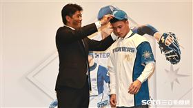 ▲孫易磊加盟日職火腿鬥士記者會，總經理稻葉篤紀幫孫易磊穿上球衣戴上球帽。（圖／記者劉彥池攝影）