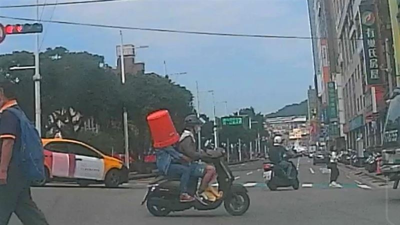 騎士乘客頂橘色大水桶　充當安全帽趴趴走