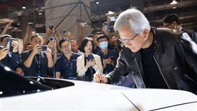 輝達（NVIDIA）創辦人黃仁勳，在鴻海董事長劉揚偉的陪同下，親自在納智捷（LUXGEN）n7的引擎蓋上簽名。（圖／鴻海提供）