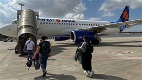 搭乘撤僑專機國人登機。（圖／外交部提供）