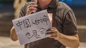 王丹在臉書貼出一張手拿「中國人的命也是命」標語的照片，他說，李克強「正常死亡的可信度，小於非正常死亡的可信度」。（圖／翻攝自王丹臉書）