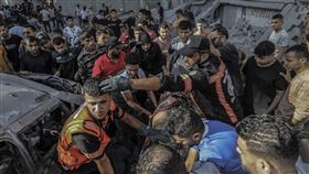 圖為以色列空襲後，巴勒斯坦緊急救援人員營救受困的受害者。（圖／美聯社／達志影像）