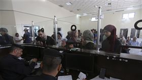 一群雙重國籍人士今天通過拉法邊界關卡離開加薩走廊前往埃及。（圖／美聯社／達志影像）