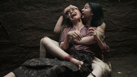 《屍禁》中邪女孩妲拉瘋狂爆咬女傭耳朵，阻止解降頭儀式的進行。（圖／威視電影提供）