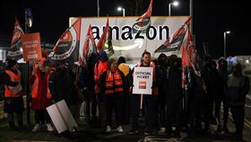 英國工會成員在科芬特里物流中心前，舉著橫幅示威。（圖／路透社）