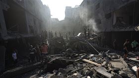 巴勒斯坦人在以色列空襲中被夷為平地的沙蒂難民營居民樓廢墟中尋找屍體和倖存者。（圖／美聯社／達志影像）