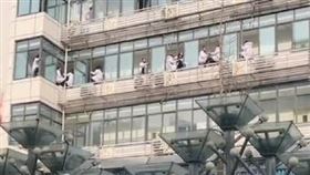 網傳中國四川一家醫院醫護人員危坐窗台，疑似為「討薪」集體跳樓。（圖／翻攝自微博）