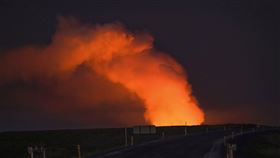 冰島當地14 日從通往格陵達維克（Grindavík）的道路上，可看見被噴發熔岩照亮的氣體。（圖／美聯社／達志影像）