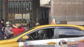 中年婦女放下三角錐後，改持機車大鎖攻擊紅衣男子，熱心路人上前勸架。（圖／翻攝自爆料公社）