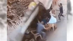 居民如往常坐在外牆下聊天，豈料圍牆突然倒塌，巨大的石塊瞬間砸向坐在牆下和路過的民眾。（圖／翻攝畫面）