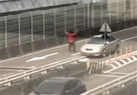新北市一名男子昨天下午出現在台1高架道路上，男子無視來往車流，站在路中高舉雙手揮舞，險遭路過車輛撞到，驚險畫面全被民眾拍下且PO網。