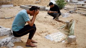 母親遭轟炸，腹中女嬰出生後幾天就過世，叔叔傷心替這對母女下葬（圖／路透／達志影像）