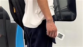 乘客上衣、褲子全穿反，手上還拿冷氣遙控器。（圖／翻攝自爆廢1公社 臉書）