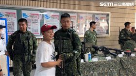 男童手握「國造狙擊槍T108」跟國軍合照，滿足全寫在臉上。（圖／記者簡榮良攝影）