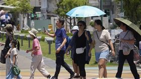 高溫炎熱  高雄民眾撐傘防曬中央氣象署表示，23日各地多雲到晴，氣溫仍偏高。圖為高雄市鹽埕區民眾撐傘防曬。中央社記者董俊志攝  113年6月23日