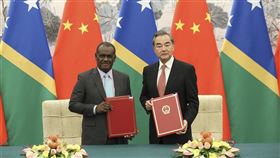 索羅門群島外交部長馬內列（左）21日與中國國務委員兼外交部長王毅（右）在北京簽署建交公報。（中新社提供）