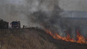 ▲黎巴嫩真主黨在以色列控制的戈蘭高地發動襲擊後，消防人員在進行滅火。（圖／美聯社／達志影像）
