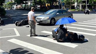 雙載機車出車禍　騎士貼心幫倒地女友撐傘