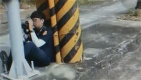 員警蹲坐躲在電線桿旁隱身執法，被路過機車騎士拍下，PO在網路社群，被揶揄是「躲貓貓執法」。（翻攝記者爆料網）