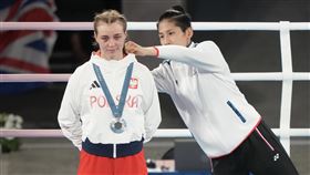 ▲台灣女兒林郁婷巴黎奧運拳擊奪金，頒獎台上幫波蘭女將塞琳梅塔（Julia Szeremeta）整體衣服。（圖／中華奧會提供）