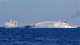 中國海警船隻5月在菲律賓海軍人員進行運補任務時噴水柱進行干擾。（圖／路透社／達志影像）