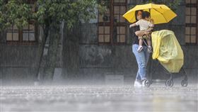 北市午後大雨（3）午後對流雲系發展旺盛，大雨範圍持續擴大到全台16縣市，台北松山文創園區23日下午也出現不小雨勢，有民眾撐傘抱著孩子、推著推車冒雨前行。中央社記者鄭清元攝  113年8月23日